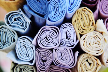 rolls of multicolored fabrics close-up.