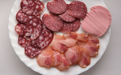 bacon, assorted sausage on a white plate