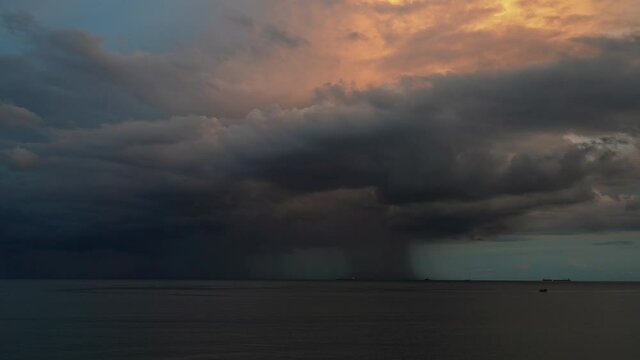 Time Lapse footage. Storm, thunderstorm at sea, ocean. A wall of rain and storm clouds move over ships anchored at sea.