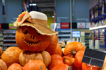 Halloween decorated Potimarron pumpkin with hat in the store, empty price tag.