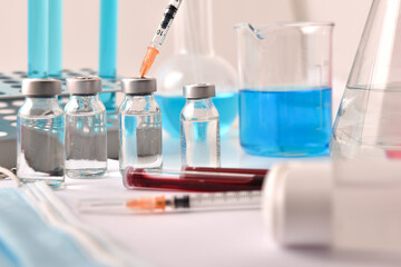 Vaccine in vial with syringe on laboratory bench chemical glassware