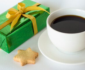 Cup of coffee on white background, star shaped cookies and gift box