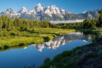 Fototapeta na wymiar Schwabacher Landing in the early morning in Grand Teton National Park, with mountain reflections on the water creek