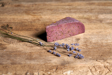 Lavender cheese with bunch of fresh lavender flowers on rough wooden planks