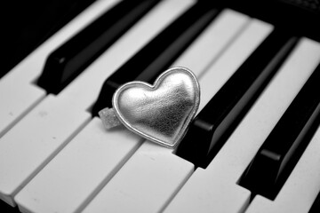 oggetto a forma di cuore posto su una tastiera di pianoforte concetto di amore e passione per la...