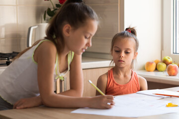 Obraz na płótnie Canvas Older sister helping younger sister to do her homework