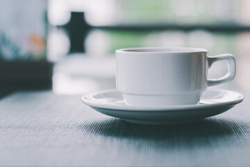 Coffee​ or tea​ cup​ white color​ on the black​ table with green nature​ background in cafe or restaurant for break time,Coffee shop business is growing rapidly and the competition is very high today.