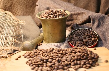 Fototapeta na wymiar Black coffee grains and a pusher for rubbing into powders