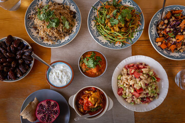 
full table healthy Indian, Asian and Mediterranean dishes with white beans, lentils, sweet potatoes, rice and vegetables