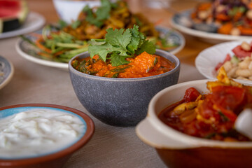 
full table healthy Indian, Asian and Mediterranean dishes with white beans, lentils, sweet potatoes, rice and vegetables