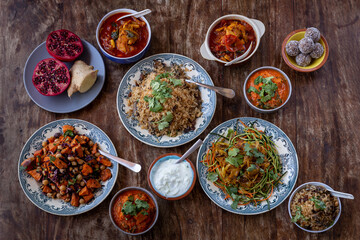 
full table healthy Indian, Asian and Mediterranean dishes with white beans, lentils, sweet potatoes, rice and vegetables