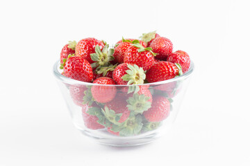 Fresh strawberry in a transparent bowl isolated on white background, side view