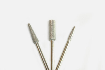 Set of three milling cutters. Manicure tool. Used manicurist professional tools on a white...
