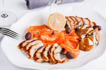 Dish with fish platter and lemon on white plate