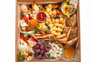 A box of food, cheese, breads, fish, shrimp. Food delivery for the company, romantic, office dinner at home. Beautiful composition of food in a box, convenient carrying, fresh products.