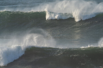 Fototapeta na wymiar large waves breaking in the open ocean during a tropical storm