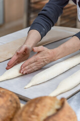 Making craft bread at the bakery. Close-up of a baker and bread, blurred background