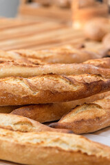 Freshly baked French baguettes lie on a light-colored surface. Rustic handicraft bread, handmade