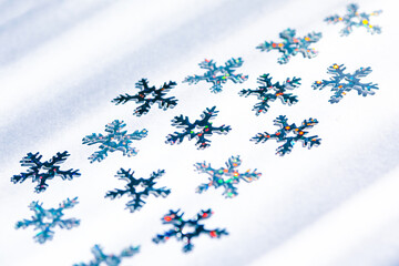 shiny blue snowflakes with multicolored sparks on white background