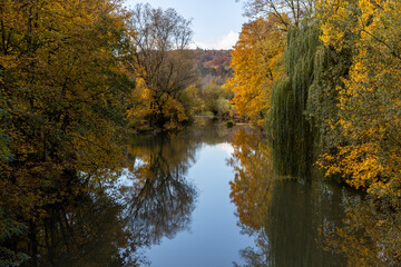 Obraz premium In dem Fluss Altmühl spiegeln sich die herbstlichen Farben der Bäume