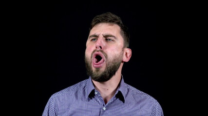 Man with sore throat coughs badly on black background