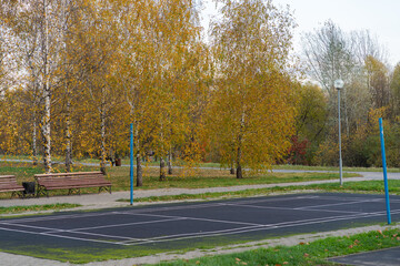 Obraz premium Deserted tennis court with trees in a public autumn park.