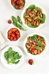 Salad with strawberry, red onion and spinach in white bowl
