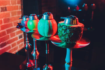 Red shisha hookah with smoke and red sparks on wood table brick, art background. Shisha Concept.