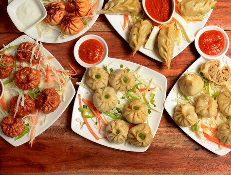 Variety of Nepalese traditional dumpling momos served with tomato ketchup and fresh salad.