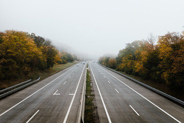 four lane motorway in autumn colours seen from a bridge. much room for text.