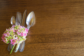 Beautiful table setting with vintage cutlery and hydrangea flowers on wooden background. Space for text, top view