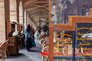 Paris cafe with written signs on glass (translation: Petit Dejeuner means breakfast, Plat du Jour means today's special)