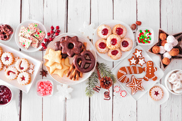 Christmas sweets and cookies. Overhead view table scene over a white wood background. Holiday...