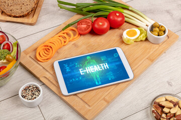 E-HEALTH concept in tablet with fruits, top view