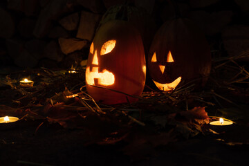 Two glowing pumpkins for halloween night on firewood background