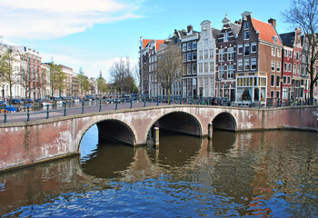 Bridge over the canal in Amsterdam and old houses on the waterfront