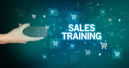 hand holding wireless peripheral with SALES TRAINING inscription, online shopping concept