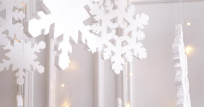 Large snowflakes on a white background with a glowing Christmas garland. Beautiful background, screen saver.