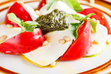 Caprese salad with mozzarella, tomato, basil and pesto