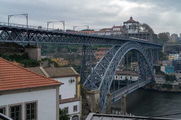 Naklejka premium The iron bridge Ponte Dom Luís I over the river Douro with boats in Porto