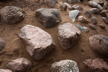 Dry granite stones in wet sand