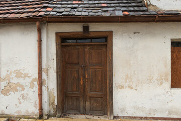 Stare, drewniane drzwi w parterowym, wiejskim domu. - obrazy, fototapety, plakaty