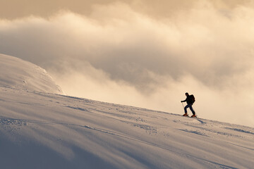 Skier on the top of mountain with clouds