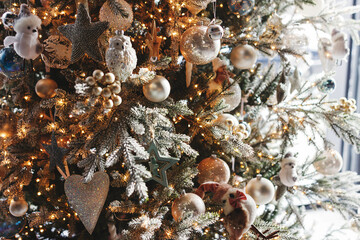 Stylish christmas tree with silver baubles and golden lights in festive room. Merry Christmas