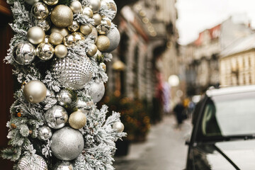 Stylish christmas baubles, silver and gold modern ornaments on storefront or building facade