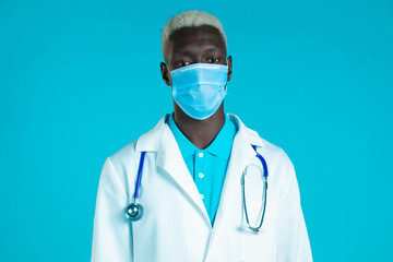 Portrait of african doctor in professional medical coat and mask. Doc man isolated on blue background.