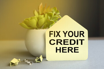 fix your credit here, text on paper on gray background