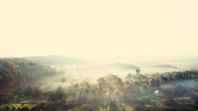 Aerial 4K footage: Flight over autumn mountain village of Breb in sunrise. Carpathian Mountains, Maramures, Romania.