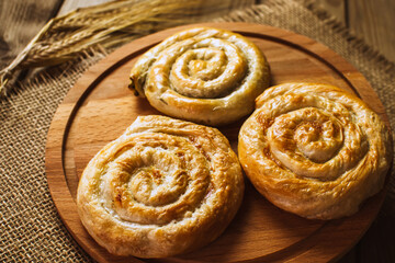Fototapeta premium Baked hearty puff pastry rolls with smoked salmon, cream cheese and fresh herbs