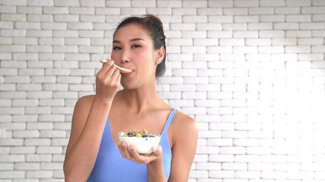 Healthy young woman eating yogurt